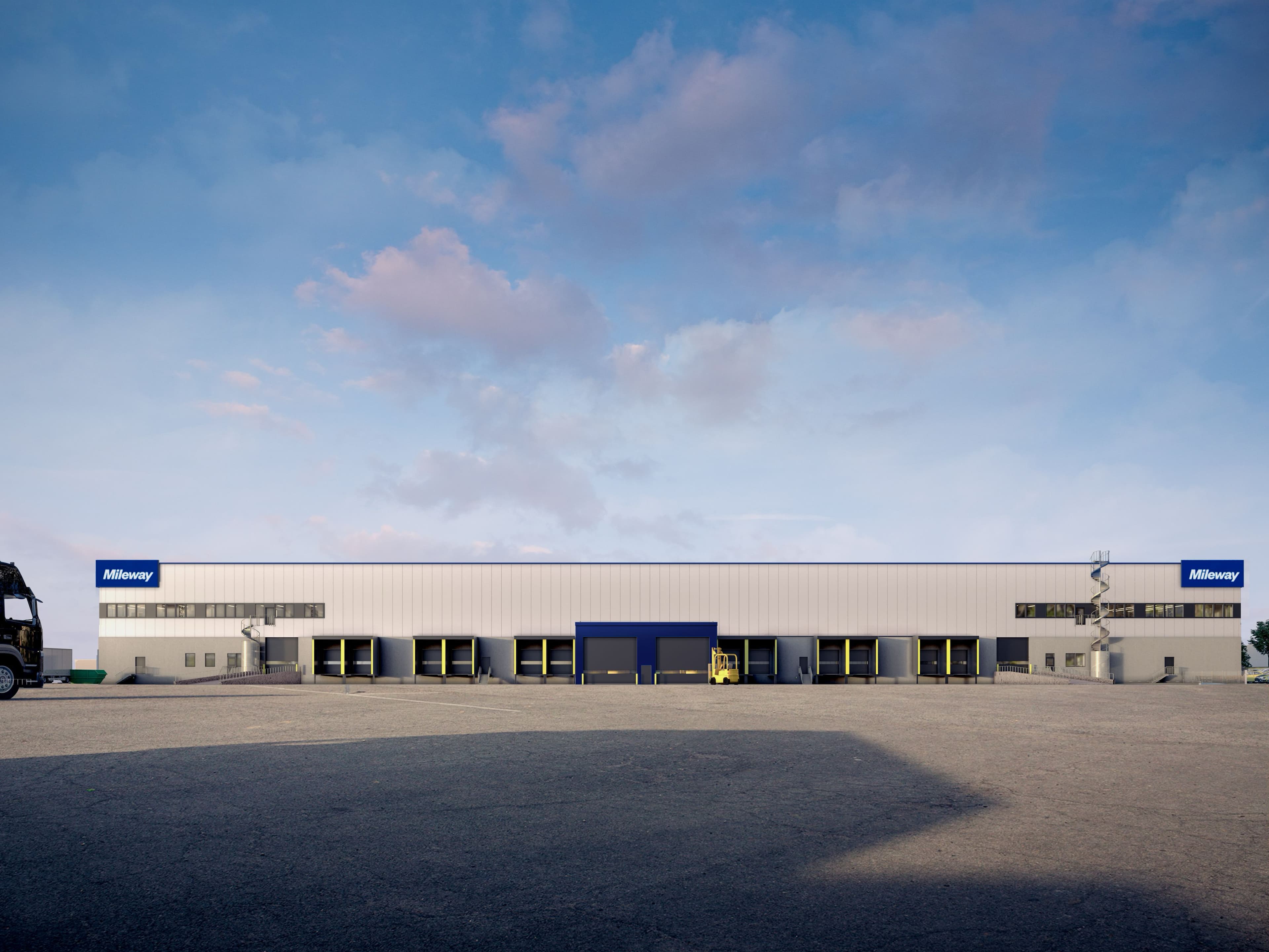 Wide-angle view of a large industrial warehouse with a sign reading Milway and loading docks.